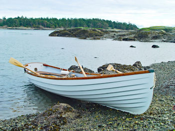 A white rowboat landed on a rocky beach